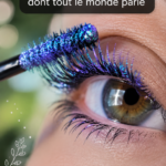 Gros plan sur un œil féminin, maquillé avec du mascara scintillant bleu et violet.